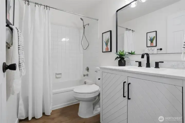 Main hall bathroom with new toilet, lighting, flooring, sink and vanity