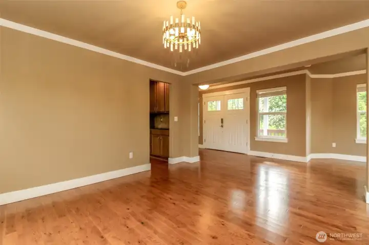 Welcoming living room featuring rich hardwood floors, designer lighting, and an open layout ideal for entertaining.