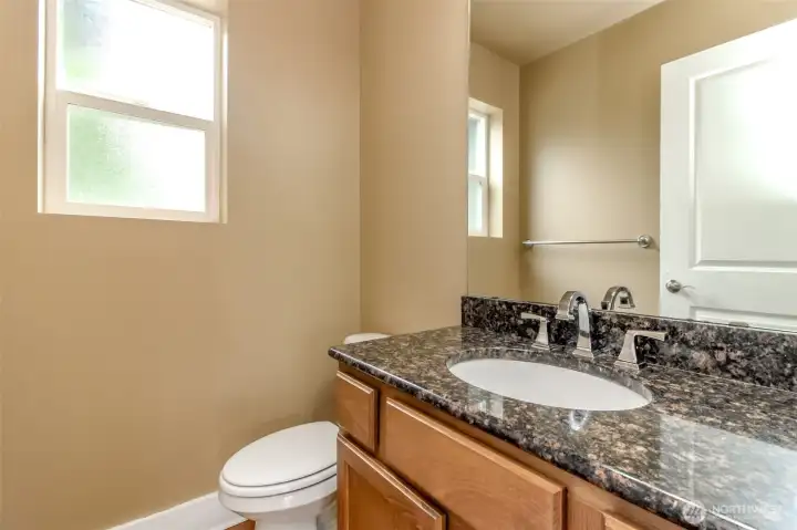 Well-appointed powder room with granite countertop and quality finishes.