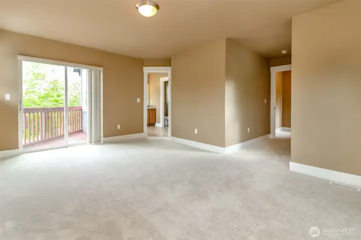 Spacious primary bedroom with private deck access and abundant natural light.