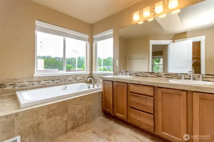 Dual vanities, soaking tub, and elegant finishes create a spa-like experience.