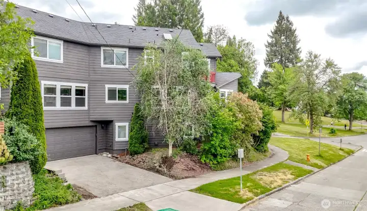 Attractive contemporary exterior situated on a desirable corner setting with mature landscaping and attached garage.