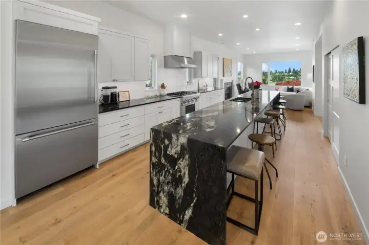 At the heart of the home is the entertainer’s dream kitchen, featuring an impressive 18-foot island, Brazilian granite countertops, subway tile backsplash, stainless steel appliance package, and beautifully crafted custom-painted cabinetry.