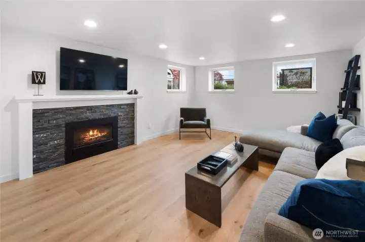 The fully finished lower level provides exceptional versatility with a spacious rec/media room centered around a gas fireplace, kitchenette, generous bedroom, full bath, and a bright oversized laundry room.