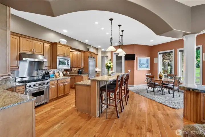 Welcome to the heart of the home chef's kitchen, center island and bar, informal eating area, lots of cabinets, pendant lighting and open to the living space