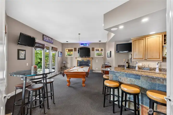 Rec room on main floor with kitchenette and access to outdoor living makes a perfect entertaining space