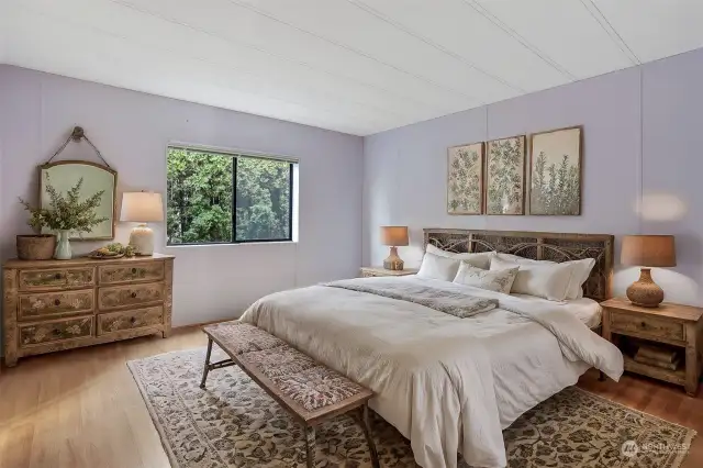 Master bedroom suite features laminate flooring, walk in closet and a 4 piece remodeled bathroom.   Virtually staged photo