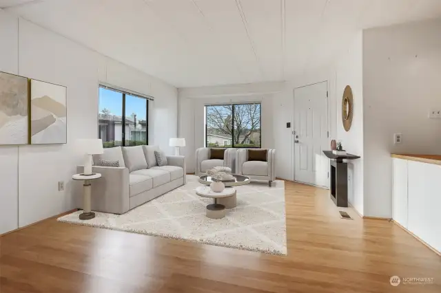 Formal living room with laminate flooring, western exposure and opens to kitchen with eating bar and dining room.  Virtually staged photo