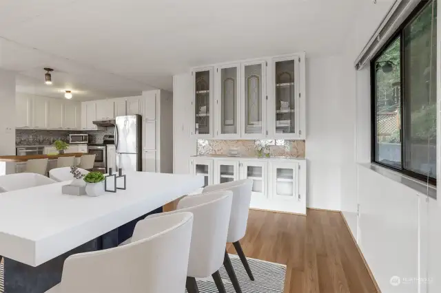 Formal dining room with laminate flooring and a built in hutch,  opens to the kitchen eating bar and living room.  Virtually staged photo