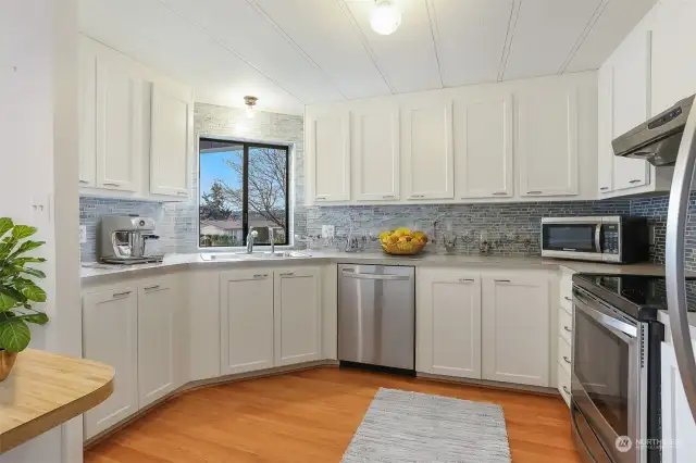 Updated kitchen with laminate flooring, refaced cabinets, stainless appliances and an eating bar.