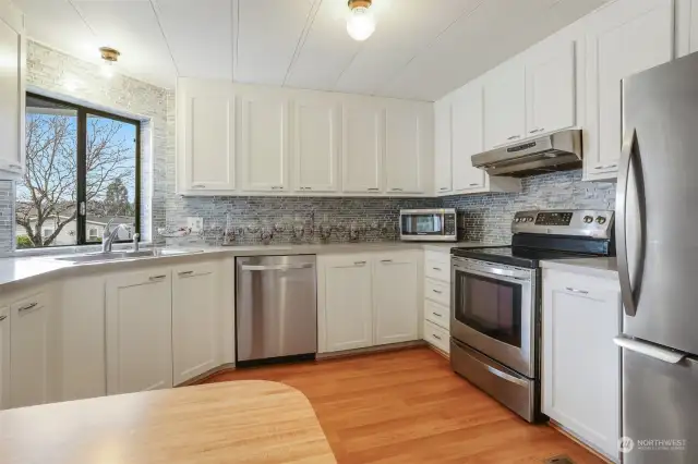 Updated kitchen with laminate flooring, refaced cabinets, stainless appliances and an eating bar.