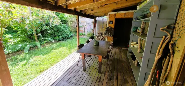 Tucked between the garden and garage, this covered deck creates a versatile outdoor haven—ideal for potting plants, casual gatherings, or simply unwinding under shelter while surrounded by the lush greenery of Nahcotta’s coastal landscape. With rustic wood tones, thoughtful shelving, and seamless indoor-outdoor flow, it’s a functional extension of the home’s charm and character.