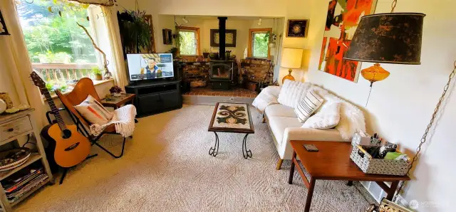 This artful space pairs rustic charm with modern warmth, featuring a cozy wood stove, built-in shelving, and rich natural light. Perfect for relaxed gatherings or creative quiet time.
