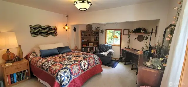 Soaked in golden coastal light and full of personality, this primary bedroom is where charm meets comfort. Wake to views of cottage gardens through oversized windows and feel the warmth of natural wood tones. It’s not just a bedroom—it’s a personal retreat that echoes the soul of the home.