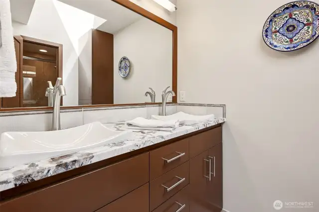 Full guest bathroom on upper level with heated floors under Travertine tile.