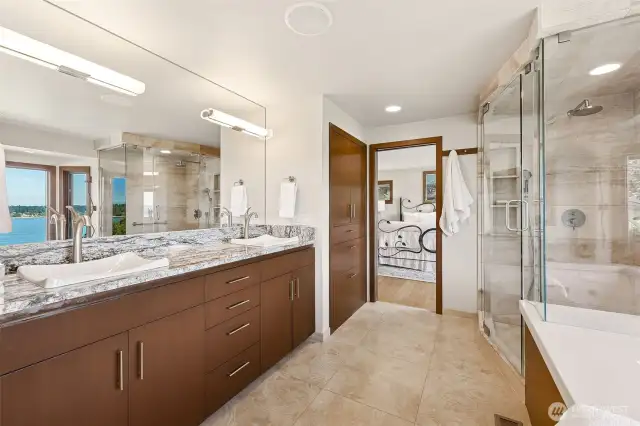 Primary bathroom with heated floors beneath Travertine tile and brushed nickel, glass enclosed Solare steam shower.
