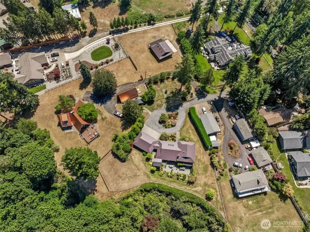 An aerial view of the estate from a different perspective, looking toward the east with the home in the foreground and the shop/barn/garage above.