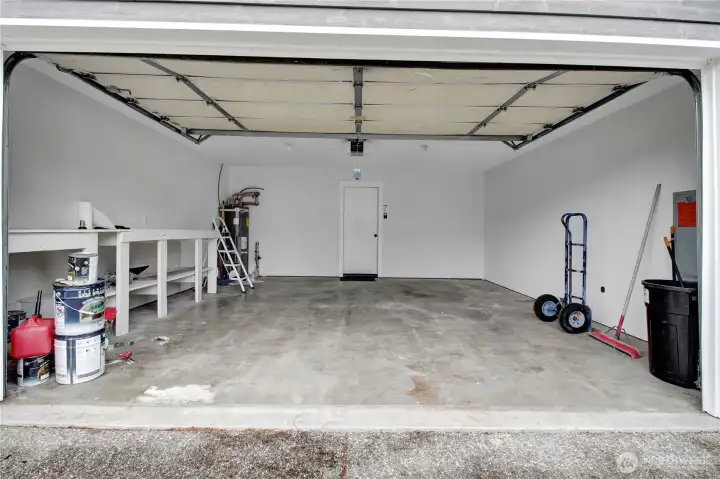 Spacious 2 car garage with storage shelving.