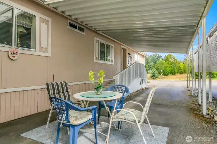 Another view of the covered dining area and carport. Entry leading to front door offers two sets of stairs (Regular height and shorter height).