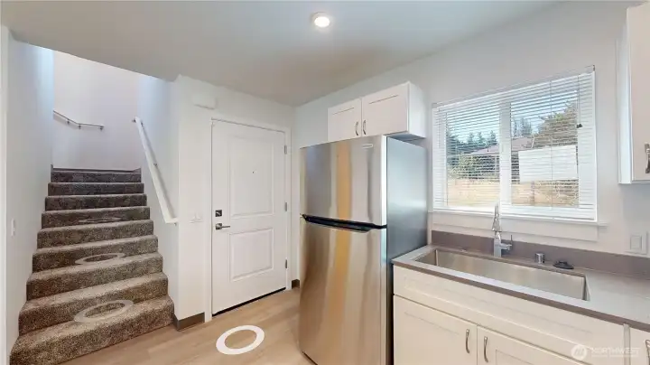 From this kitchen you'll find stairs to second level and door to backyard