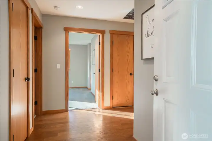 The open door on the far left is the second bedroom or office.  The open door is the primary bedroom.  A right hand turn will lead to the living room, dinning area, kitchen and the beautiful backyard.