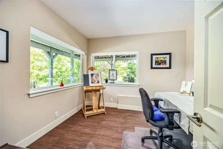 The second guest bedroom on the lower level—formerly used as an artist’s studio—features tall ceilings, abundant natural light, and a quiet corner location, making it an ideal retreat for guests or a versatile flex space.