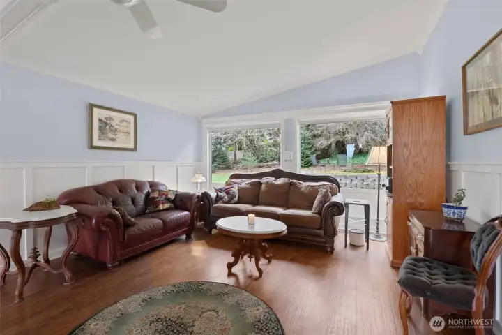 Living room with large windows gazing into the private back yard. Ceiling fan pushes the heat form the double sided fireplace.
