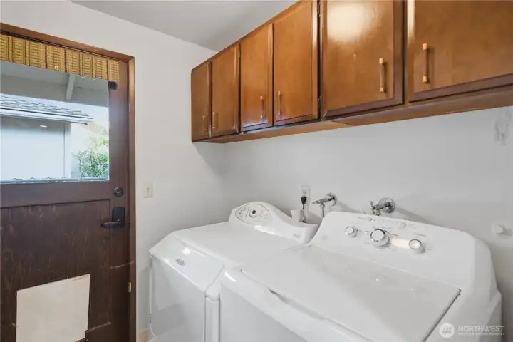 Laundry room with built-in cabinetry for extra storage.