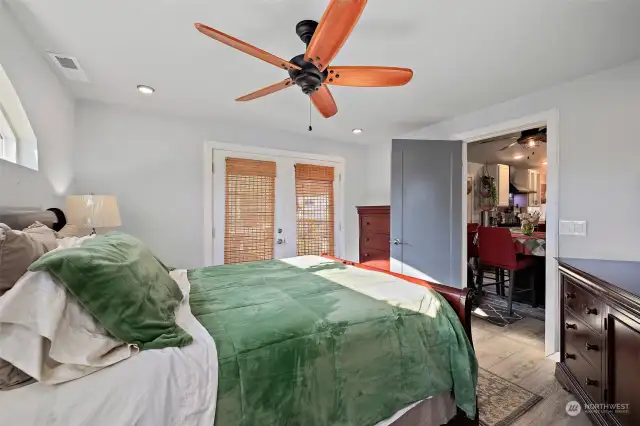 Primary bedroom with French doors leading out to back deck and hot tub.