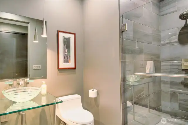 This delightful powder room for guests also has a 3/4 tiled shower.
