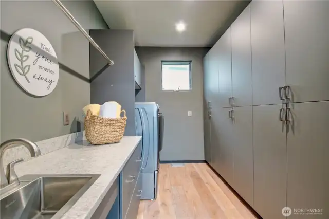 Everyone would love this laundry room. Plenty of storage space and workspace, together with sink.