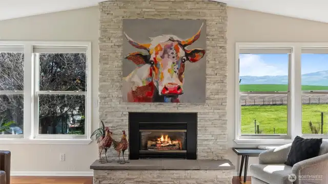 Stately stone-wrapped gas fireplace and hearth.