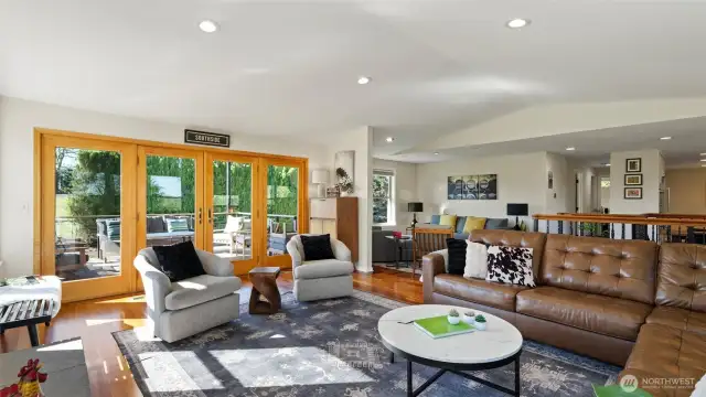 The expansive great room is accented by vaulted ceiling and beautiful wood trim on the double french doors.