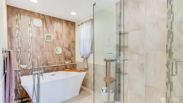Extra deep soaker tub plus walk-in glass surround shower really elevates your experience in this primary bathroom.