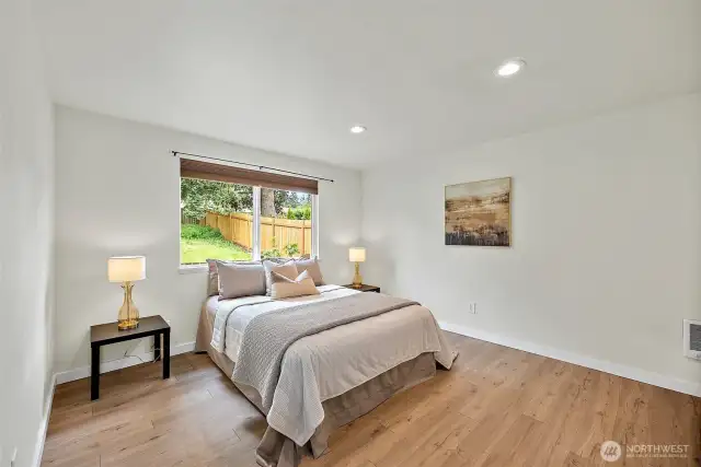The spacious primary bedroom is filled with natural light and views of the back yard, offering the perfect escape at the end of your day.