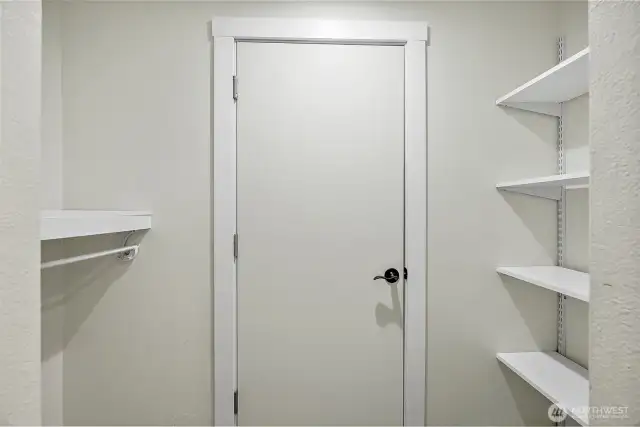 This walk-in closet offers practical built-in shelving and hanging space, making organization simple and satisfying.