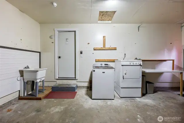Dedicated laundry area with utility sink, ample workspace, and washer/dryer setup—ready for daily use.