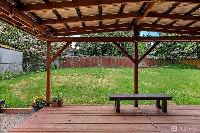 Covered deck with overhead lighting and bench seating—perfect for relaxing or hosting guests in your private fully fenced backyard.