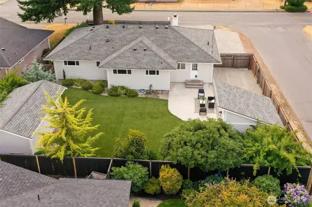 Fully fenced rear yard has large sunny patio, easy-care turf and lovely mature landscape. RV parking in upper right corner (with plug), 120 sf studio/office right of patio, 200 sf workshop at left.