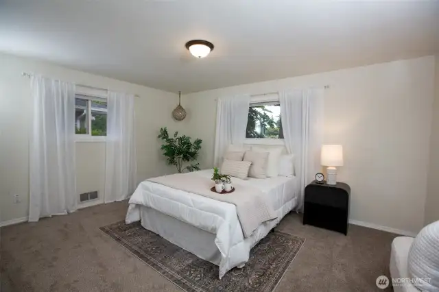 Serene and surprisingly spacious primary bedroom offers peaceful retreat at the end of the day.