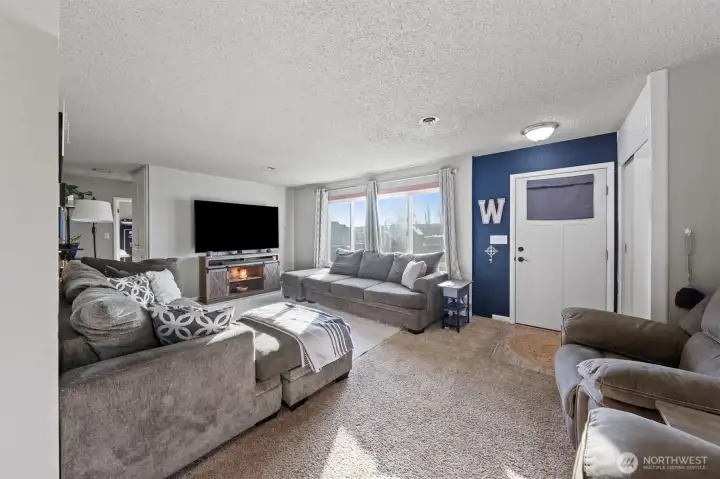 Living room is light and bright with large windows and modern paint colors