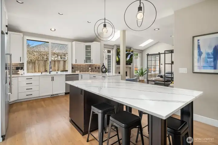 The heart of the home is the UPDATED kitchen, featuring custom cabinetry, an oversized island perfect for homework or hosting...