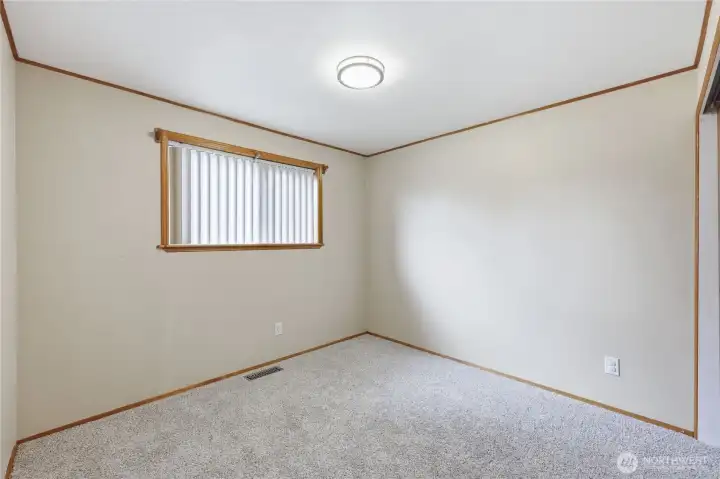 Light-filled additional bedroom with soft carpet, ideal for guests, a home office, or flex space.
