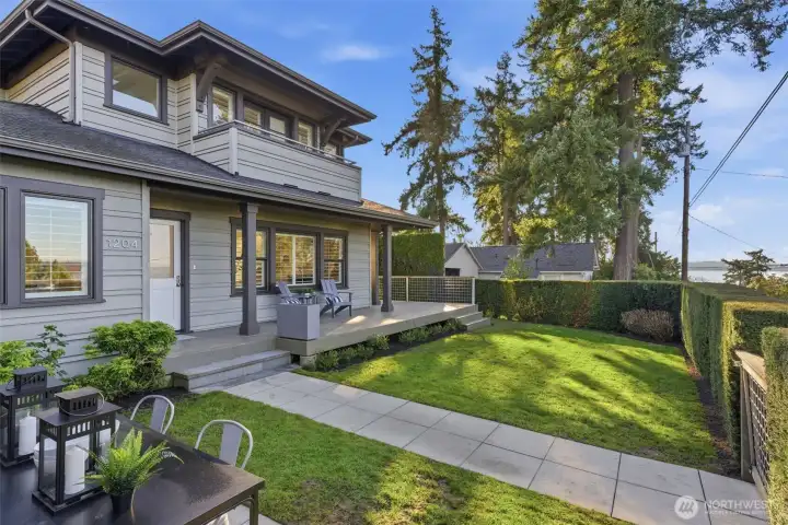 The yard receives equal parts sun and shade throughout the day, and the covered front porch affords year-round enjoyment of this blissful setting and Lake Washington views.