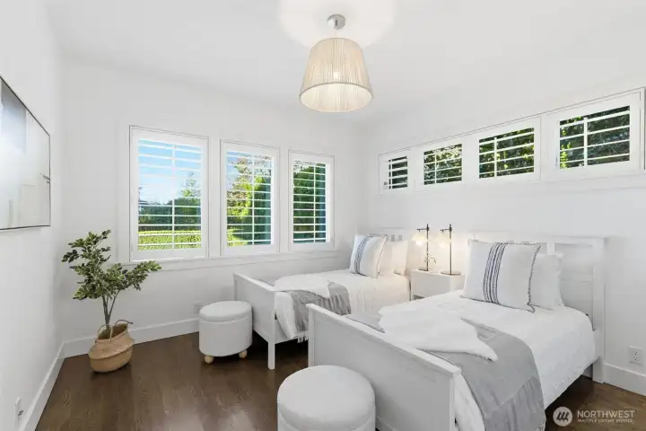 Another bedroom overlooking the front yard, also with high windows filled with seasonal camelia blooms.