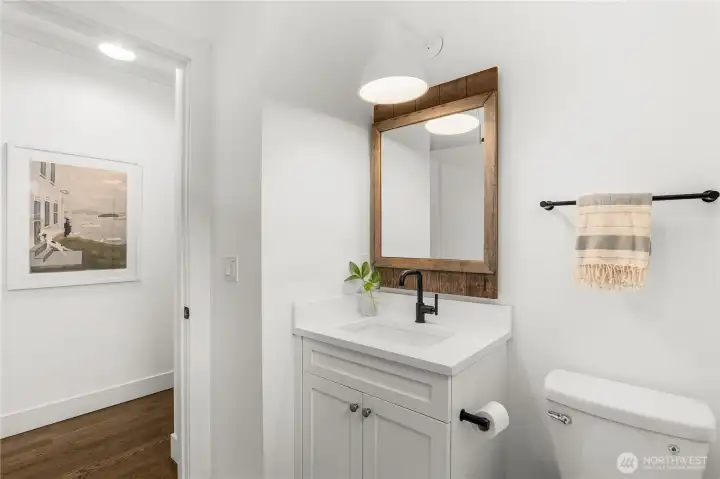 Additional bathroom with tub/shower and enamel wall light from Schoolhouse Electric.