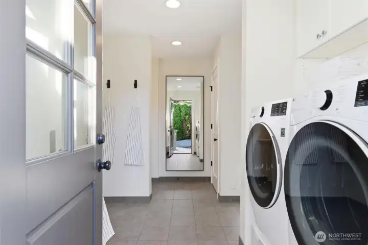 Delightful mudroom/laundry room connects basement, kitchen, garage, and back door. Storage closet shown to right. Sturdy steel wall hooks from Room & Board. Newer LG washer and dryer.
