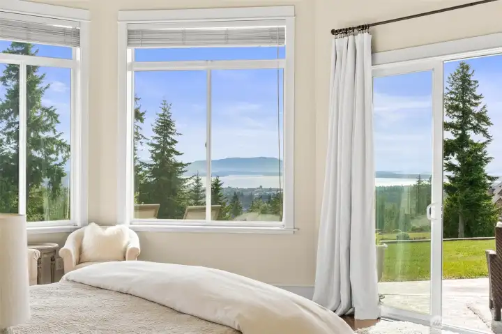 Huge primary bedroom with incredible views to wake up to! There are sliding glass doors out to the patio, gorgeous solid wood French doors, and his & hers closets.