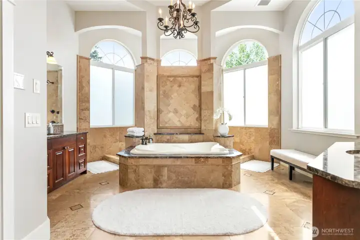 Primary bathroom with double vanities, step-through shower with 3 shower heads, and double soaking tub