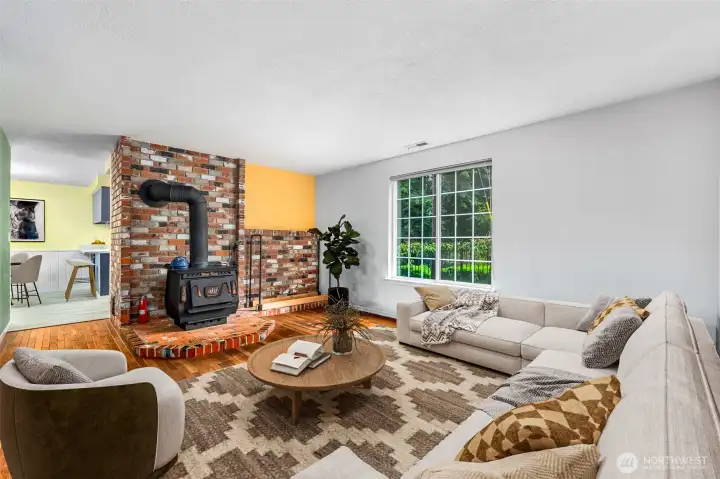 The large living room with original wood floors. The wood stove will help with those ever-rising heating bills. Wood stack in the yard stays too! This photo is virtually staged.
